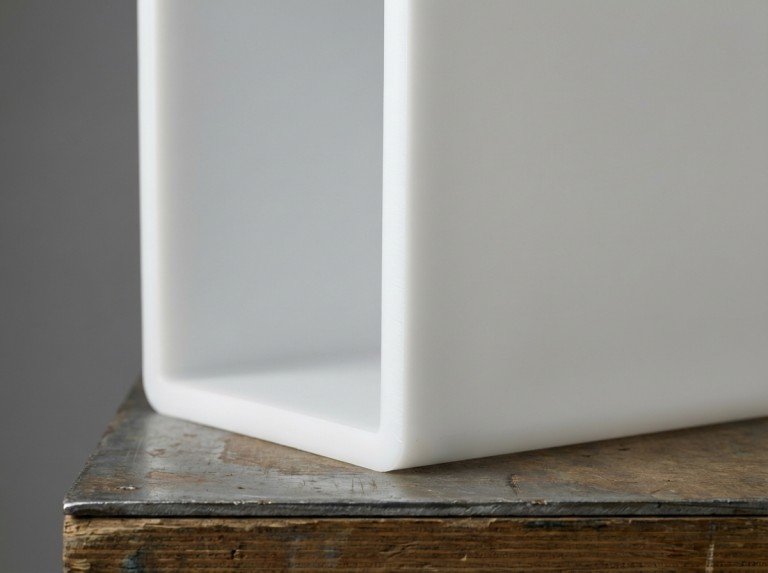 Plastic storage box being cut with a fine-tooth handsaw along a taped cut line